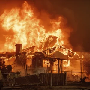 The Eaton Fire burns a structure Jan. 8 in Altadena, Calif. (AP Photo/Ethan Swope)
