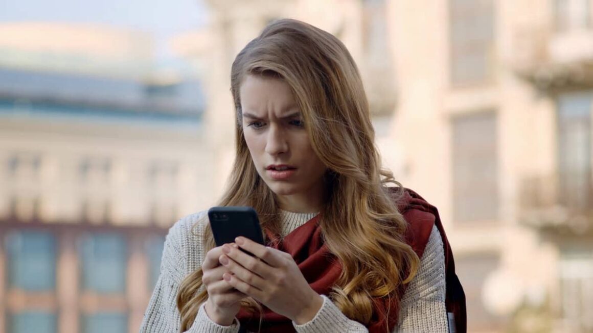 woman shocked looking at phone