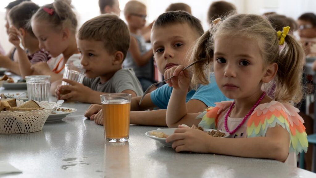 Experts Say Russia’s Mass Abduction of Ukrainian Children Is a War Crime As many as 35,000 Ukrainian children are missing and believed to be held in Russia or areas controlled by Russia, according to experts from Yale University. Families are taking desperate steps to try to bring their children back. Since Russia’s invasion began in February 2022, children have been taken from care homes, battlefields, and even directly from their families. Russia denies demands to return the children and claims Ukraine is “staging a show” about the issue. One mother, Natalia, shared how she rescued her two sons from a children’s camp in Russia after months of being separated. She traveled alone for six days through checkpoints before reuniting with them. The Yale team calls this the largest child abduction in war since World War II, comparing it to Nazi Germany’s forced Germanification of Polish children. Only 1,366 children have so far been returned or escaped. Many children are placed in military camps, foster care, or adopted by Russian families. Rescued children describe being punished for speaking Ukrainian and forced to learn Russian symbols and anthems. Experts warn that if children are placed in orphanages or adopted, it becomes nearly impossible to bring them back to Ukraine. The international criminal court agrees these actions are war crimes. In March 2023, it issued arrest warrants for Russian President Vladimir Putin and children’s commissioner Maria Lvova-Belova for unlawfully deporting Ukrainian children. Ukraine demands the return of all abducted children in any peace talks. Experts say Russia is using the children as bargaining chips in negotiations.
