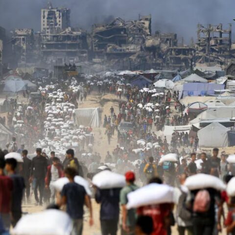 Palestinians gather as they carry aid supplies that entered Gaza through Israel, amid a hunger crisis, in Beit Lahia in the northern Gaza Strip July 20, 2025.