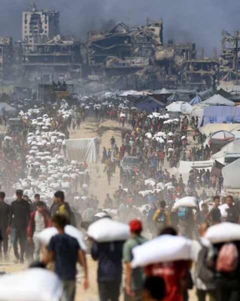 Palestinians gather as they carry aid supplies that entered Gaza through Israel, amid a hunger crisis, in Beit Lahia in the northern Gaza Strip July 20, 2025.