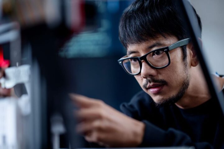 Guy Sitting Infront & Looking At a Computer