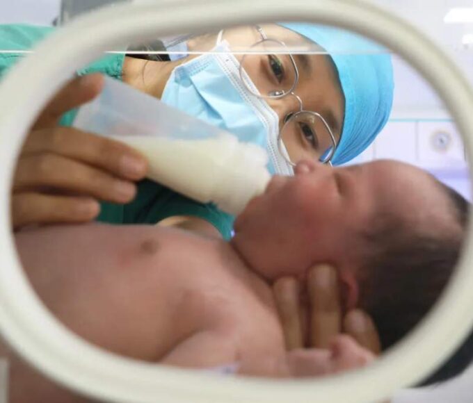 A nurse feeds a newborn baby at a maternal and child health hospital