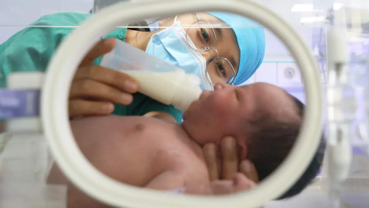 A nurse feeds a newborn baby at a maternal and child health hospital