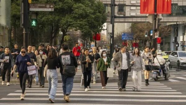 Pedestrians cross a road in the Xintiandi shopping area in Shanghai.