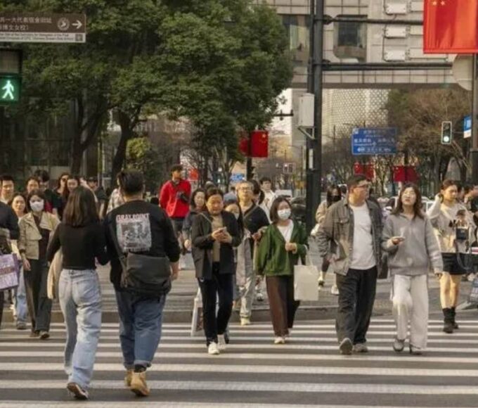 Pedestrians cross a road in the Xintiandi shopping area in Shanghai.