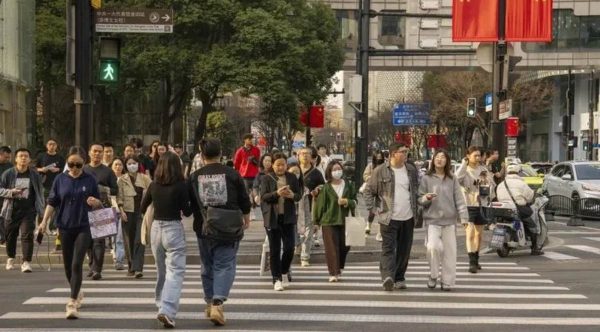 Pedestrians cross a road in the Xintiandi shopping area in Shanghai.