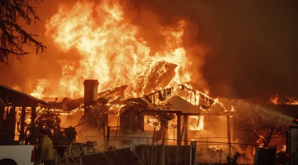 The Eaton Fire burns a structure Jan. 8 in Altadena, Calif. (AP Photo/Ethan Swope)